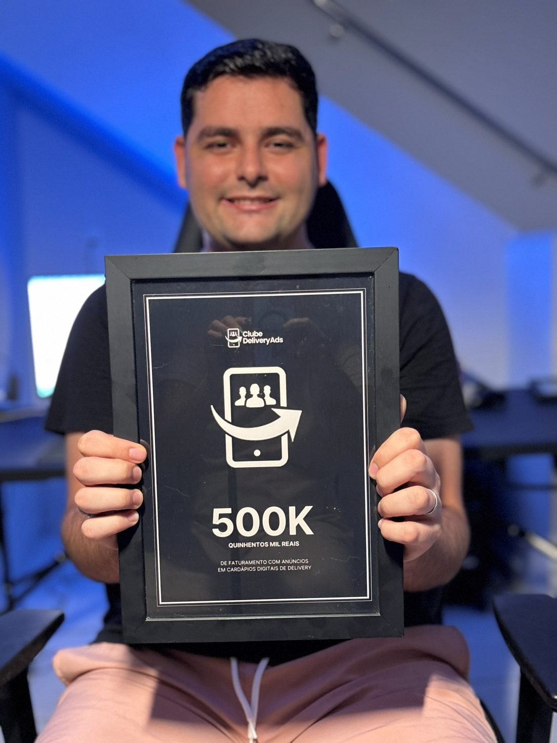 Guilherme Kemerich segurando a placa de reconhecimento de R$500 mil de faturamento com anúncios em cardápios digitais de delivery